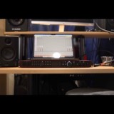 Focusrite Scarlett 18i20 interface and M-Audio monitors on the rack shelf with a session running on screen