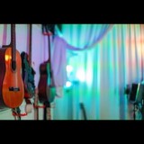 Acoustic and electric guitars hanging on the wall of the Studio San Francisco live room beside a modular white isolation curtain