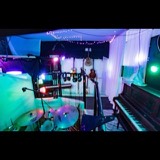 The Studio San Francisco live room seen from behind the drum kit, with microphone stands, guitars and an upright piano