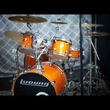 The studio's orange Ludwig drum kit with cymbals, set up and miked in front of an acoustic panel